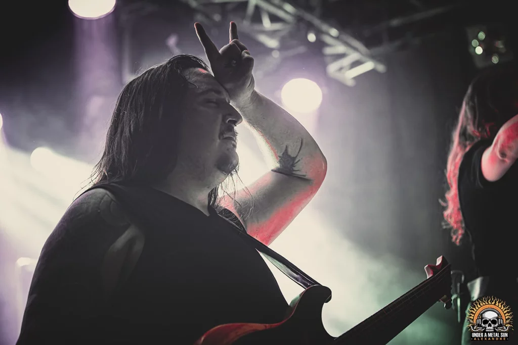 Alexandre, le guitariste, salue le public du signe des cornes - Under a Metal Sun Alexandre, le guitariste, salue le public du signe des cornes - Under a Metal Sun
